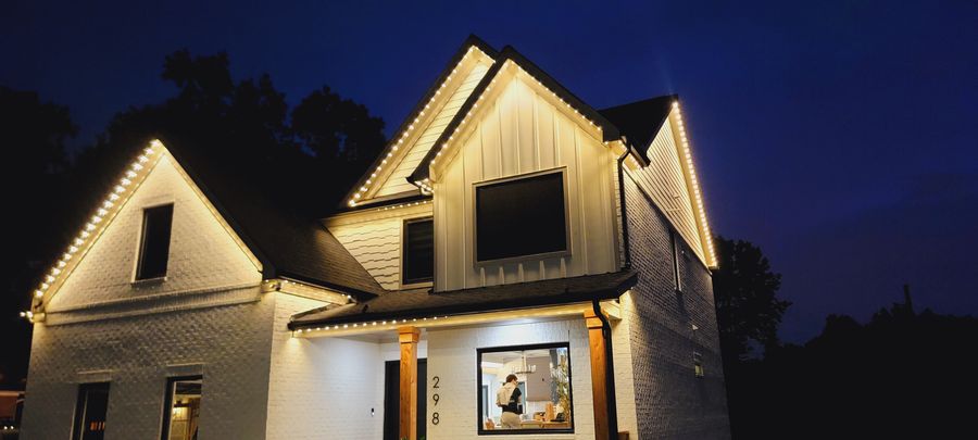 Warm white permanent lighting on modern farmhouse at night